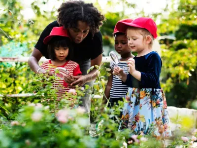 A group of children look at plants with an adult